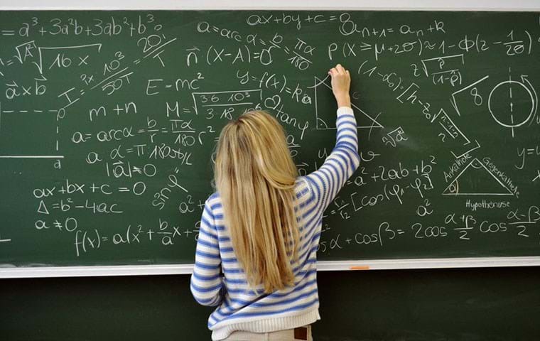 A student answers a complicated maths query on a blackboard