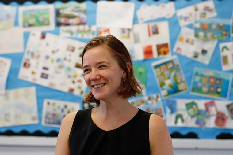 A teacher smiles in front of her class