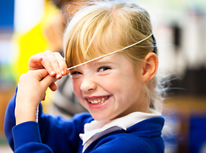 Primary Smiling Girl With String On Head