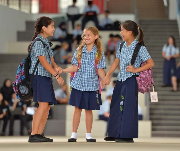 school girls holding hands in corridor
