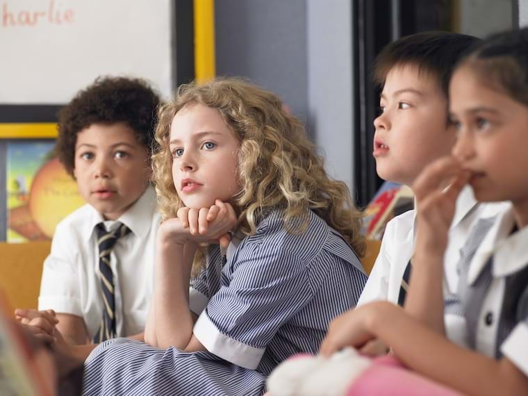 children in classroom with girl staring attentively