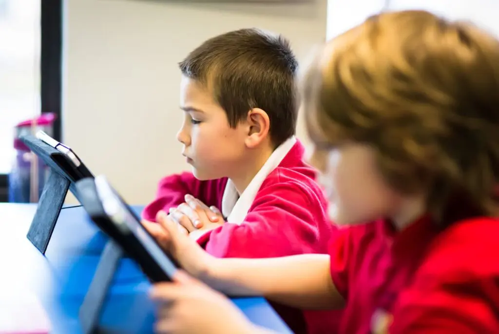 Primary school children using tablets in a classroom.