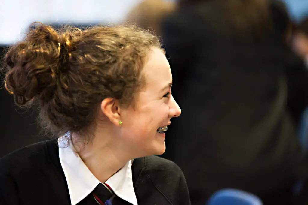 Smiling teenage girl in school uniform.