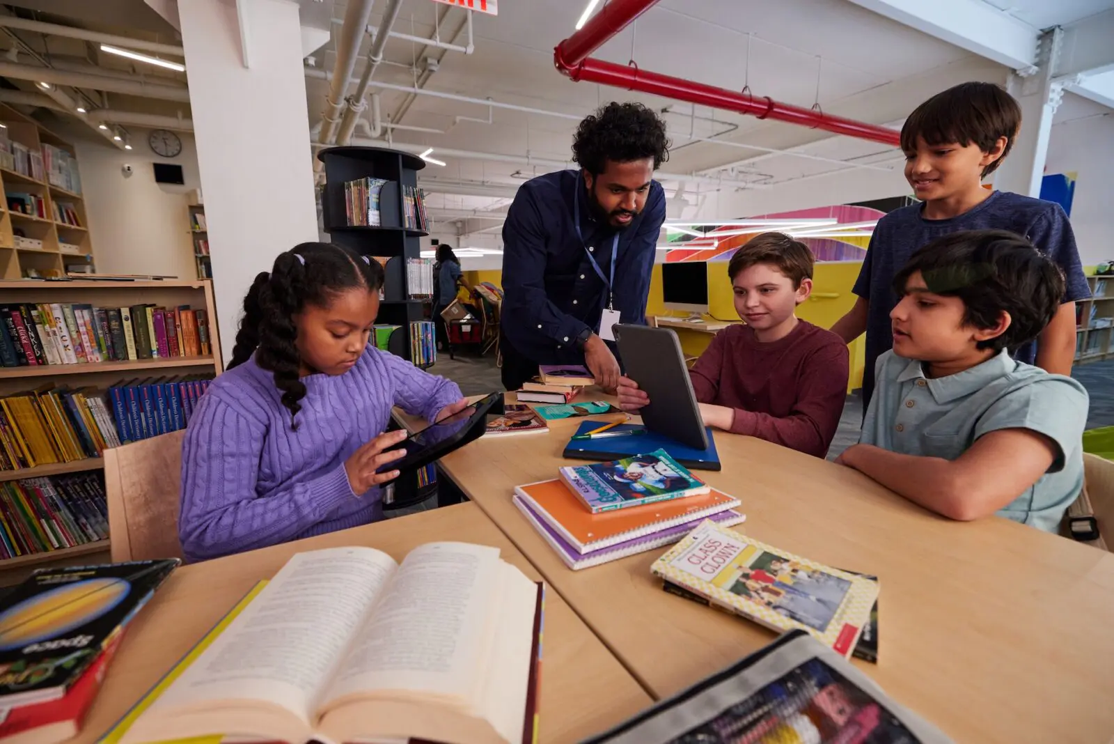 Teacher helping students in library